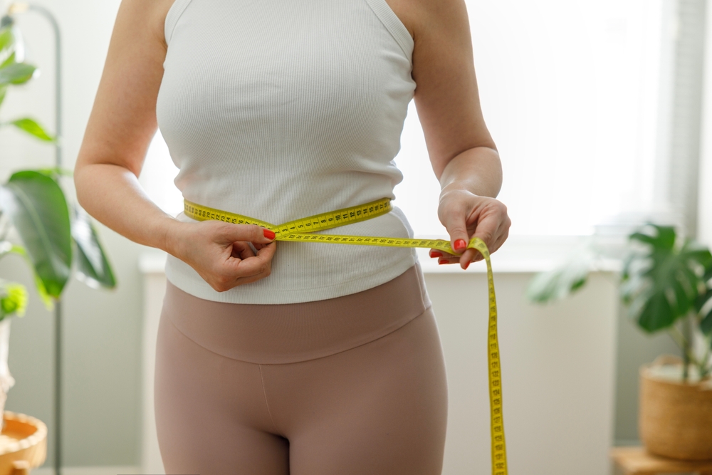 woman measuring herself after medical weight loss